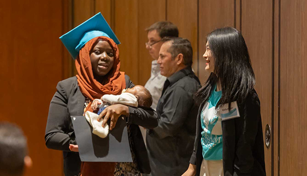 MaKami College graduate with her child